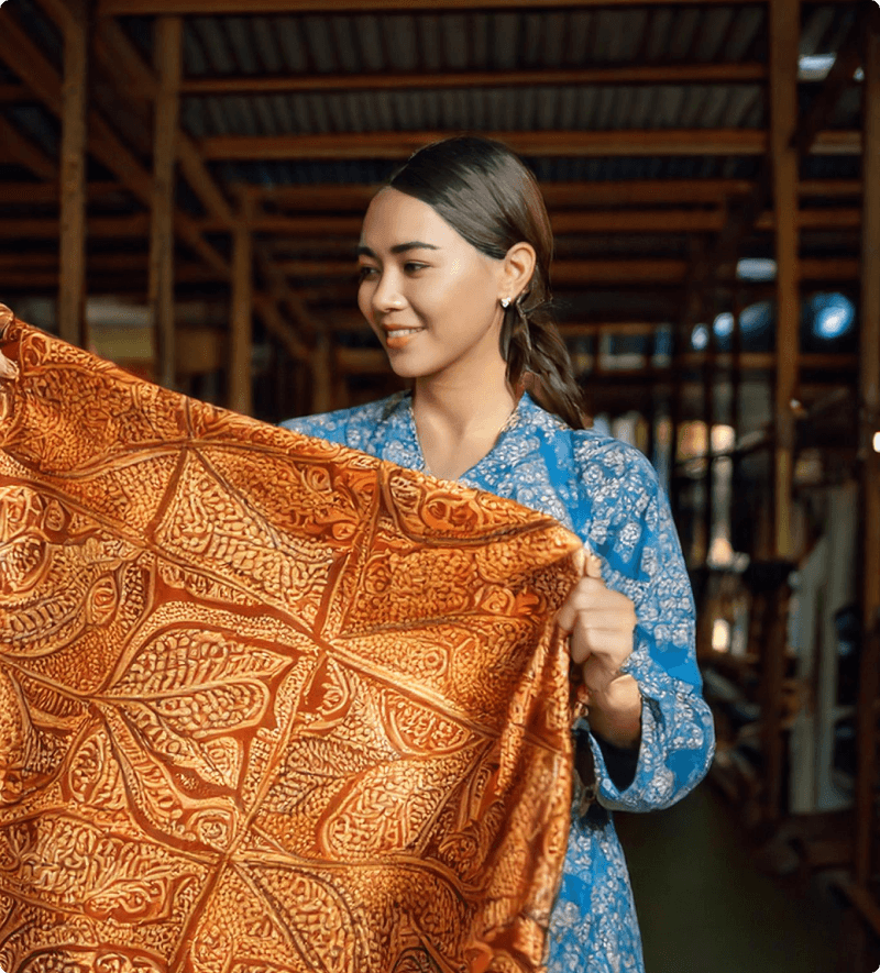 batiksingapore woman holding batik fabric.png__PID:afd31177-35f1-4228-bd1f-64a31a258adf